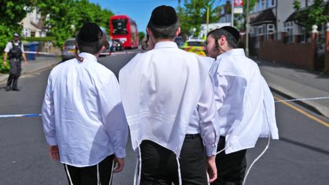 Jewish youths gather at the police cordon near the scene where two people were stabbed on April 29, 2026 in the Golders Green area of London, England. 