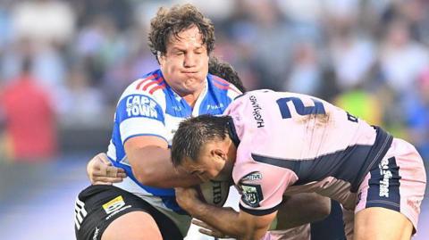 Neethling Fouché of the Stormers (L) is tackled by Cardiff's Liam Belcher