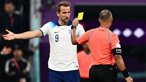 Harry Kane argues with Brazilian referee Wilton Sampaio as he shows a yellow card