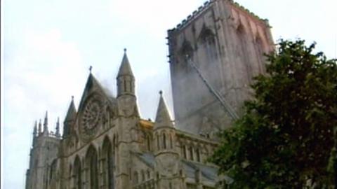 Smoke coming out of York Minster, with firefighter ladder reaching up into the building.
