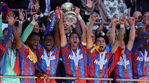 Crystal Palace players celebrate as they lift the FA Cup in the air