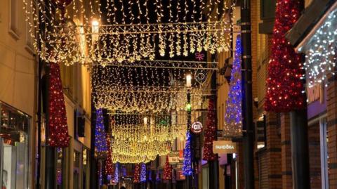 Gold red and purple lights along Strand Street.