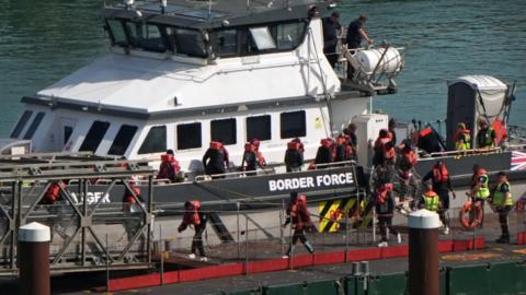 A group of people thought to be migrants are brought in to the Border Force compound in Dover, Kent. 