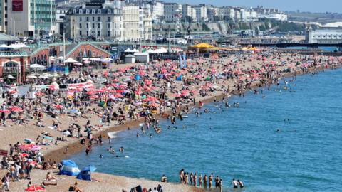 Aerial shot of crowds of people on Brighton beach next to the pier on Monday