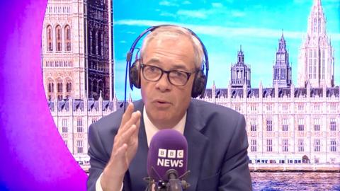 Nigel Farage in a blue blazer and white shirt in front of a BBC News microphone.
