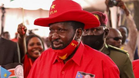 Salva Kiir, the President of South Sudan, in a red hat with words 'SPLM' and a red shirt