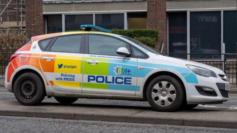 A Northumbria Police car parked in the city centre. It has been decorated in Pride colours and has the words Policing with Pride displayed on its door.