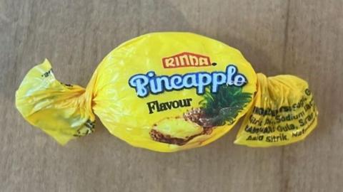 A sweet wrapped in Rinda brand pineapple flavour sweet paper