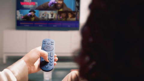 Woman watching Sky Glass with remote in hand