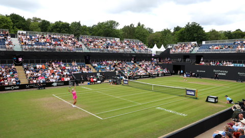 A general view of play during the Women's Singles Final match between Ajla Tomljanovic of Australia and Yulia Putintseva of Kazakhstan in June 2024. Crowds of people are in tiered stands around the grass court with advertising hoardings surrounding it