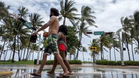 People walk on Ocean Dr in Miami beach, Florida, USA, 01 August 2020