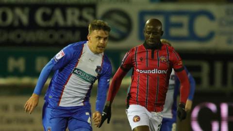 Carlisle's Archie Davies is chased by Walsall forward Albert Adomah