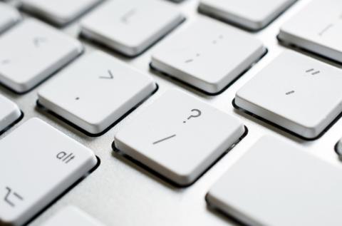 A close-up picture of punctuation buttons on a keyboard.