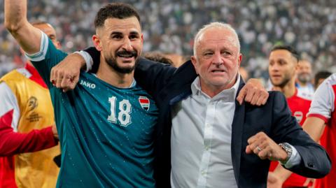 Aymen Hussein (L) raises his fist as he celebrates alongside Iraq head coach Graham Arnold (R) in Basra, Iraq, o