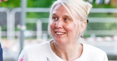 Sath chief executive Jo Williams has blond hair tied back and is looking to the left with a smile on her face. She is wearing a white top.