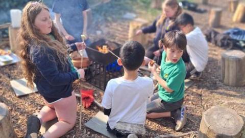Pupils toasting marshmallows in forest school