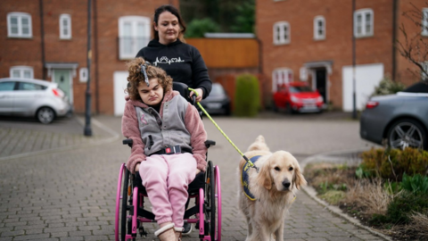 Karen and her daughter Josselin,16, with their buddy guide dog, walking near their home in Westbury, Wiltshire