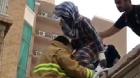 Ethiopian maid helped from roof after falling from the window of an adjoining block of flats (30 March 2017)