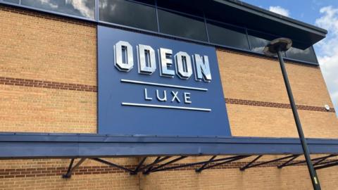 Odeon LUXE sign on an orange brick building, with a black canopy above and below