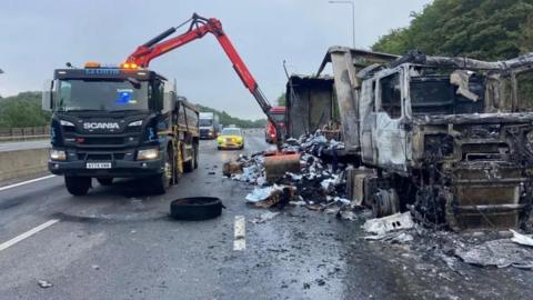 Burnt out lorry on motorway.