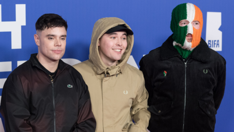 Kneecap members Moglai Bap in a black bomber jacket, Mo Chara in a beige hooded jacket and black baseball hat and DJ Provai in a black bomber jacket and green white and orange Irish tricolor balaclava attend the British Independent Film Awards 