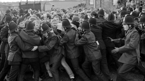 A large crowd of Tilmanstone miners are held back by a line uniformed police officers in Kent