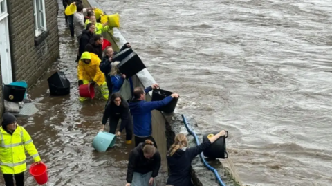 Residents try to bail water away from their homes in Pontypridd, south Wales