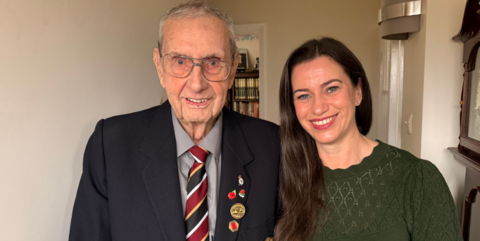 Tracy Richardson and her neighbour Arnold, a WW2 veteran who is wearing a suit with several poppies and an army medal