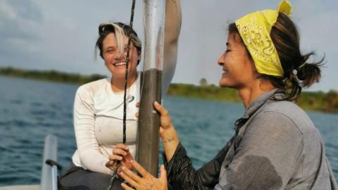 Scientists hold a mud core drilled from the shores of the Amazon River in Brazil