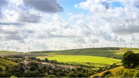 Long range view of wind turbines in the countryside - stock photo