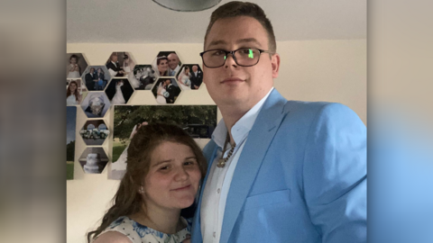 Shannon Watson and Ben Wright take a selfie, Ben is wearing glasses and a blue suit, Shannon has a white top with blue flowers