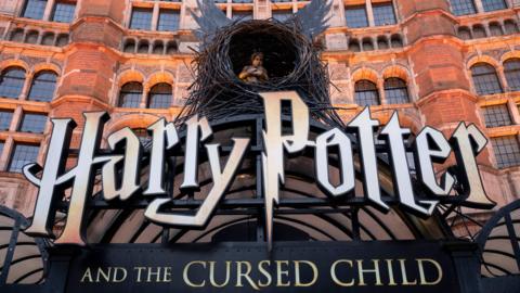  Harry Potter and the Cursed Child sign with biy inside a nest with wings outside a red brick building