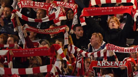 Arsenal fans hold up scarves