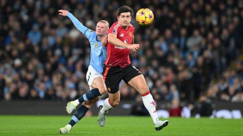 Erling Haaland of Manchester City in action alongside Harry Maguire of Manchester United