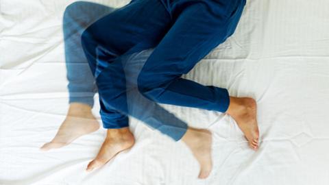 A pair of legs moving in bed