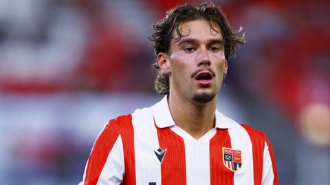 Milan Smit in action for Stoke City. He is wearing a red and white striped home shirt