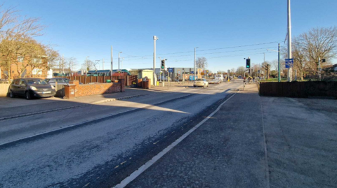 A road leading up to a tram track on a bright and frosty day