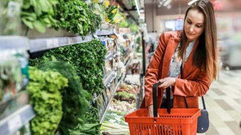 A woman with long brown hair in a shopping aisle