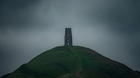 Glastonbury Tor with dark, cloudy background