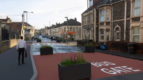 A computer generated image of planned changes to a street in east Bristol. A stretch of the road is covered with red tarmac and the words "bus gate". Planters block the road to other traffic.