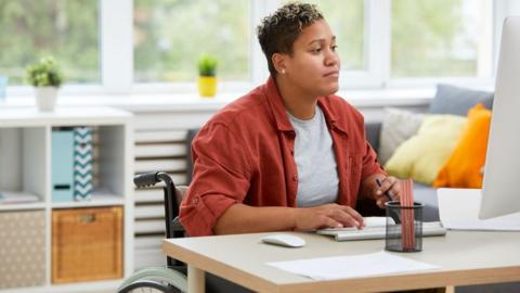 A wheelchair user studying at home (generic)