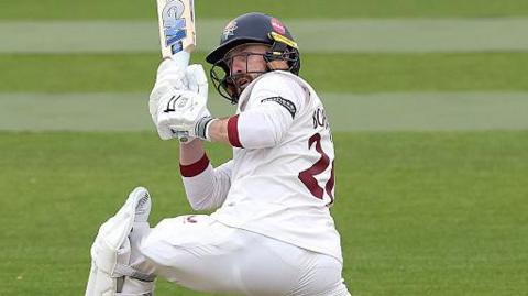 Lancashire batsman Josh Bohannon going down on one knee to pull the ball to the boundary against Northamptonshire.