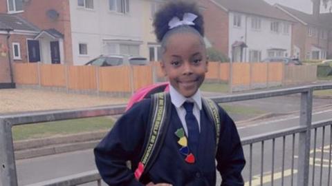 A little girl in school uniform