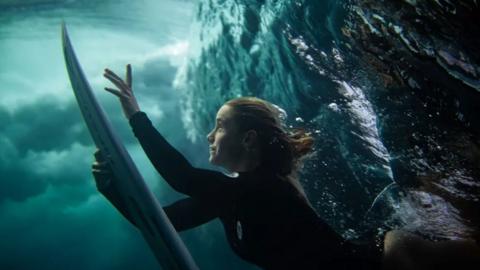 Surfer rising from under the waves in the Solomon Islands