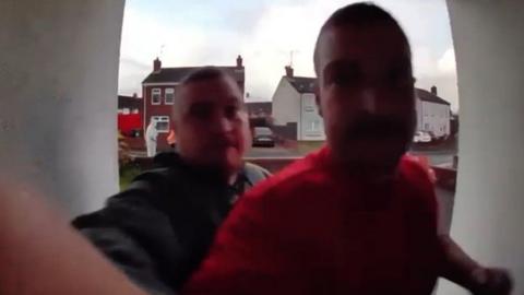 A screengrab from Ring doorbell footage showing Adrian and Alister Douglas. One is wearing a black jacket and the other a red T-shirt