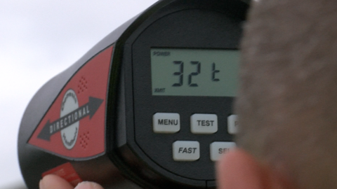 A close-up of a volunteer using a speed gun