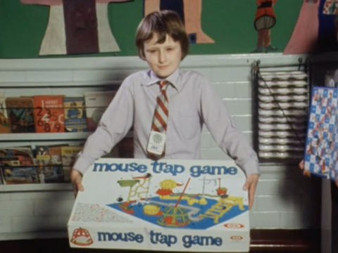 Child holding box for mouse trap board game.