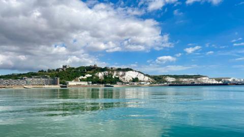Calm seas and blue skies with the white cliffs of Dover in the background