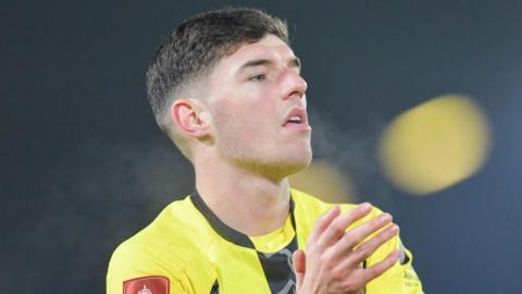 Harrogate Town player Ellis Taylor applauds the fans.