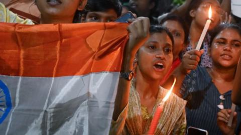 Women protesting, holding flags and candles